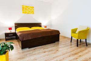 1 dormitorio con 1 cama y 1 silla amarilla en Sentami en Žilina