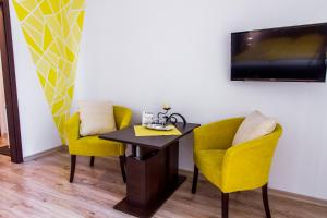 a dining room with two yellow chairs and a table at Sentami in Žilina