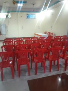 a group of red chairs in a room at Hotel Radhika kunj palace,Chhatarpur in Chhatarpur