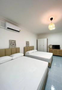 a room with three beds and a television in it at Rainhill@Betong in Betong