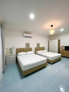 a bedroom with two beds and a television in it at Rainhill@Betong in Betong
