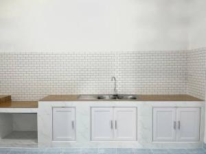 a kitchen with white cabinets and a sink at Rainhill@Betong in Betong +24 photos