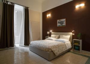 una camera con un grande letto e una grande finestra di Corte Nicolaiana Apartments by Wonderful Italy a Bari
