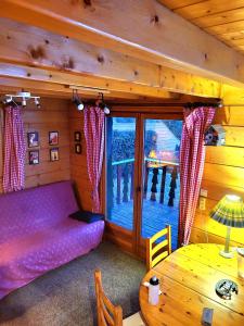 a living room with a purple couch and a table at Maison de bois finlandaise au pied des pistes in Bolquere Pyrenees 2000