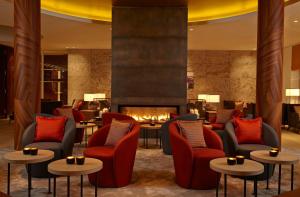 圣彼得奥尔丁阿勒尔福斯Spa酒店的大堂设有桌椅和壁炉。