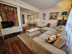 a living room with a couch and a tv at Amplio piso en la playa de 135 m2 con garaje in Zarautz