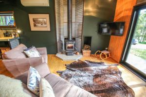 a living room with a couch and a fireplace at Black Mamba House in Harrietville