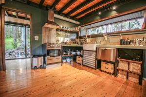 a large kitchen with wooden floors and a large window at Black Mamba House in Harrietville