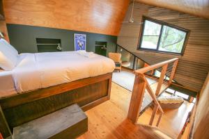 a bedroom with a large bed and a staircase at Black Mamba House in Harrietville