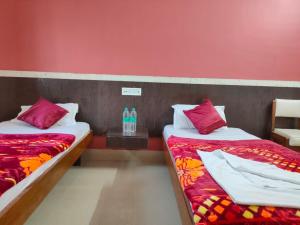 - 2 lits dans une chambre aux murs rouges dans l'établissement Hotel Vaishnavi near Baba Dham Temple, à Deoghar
