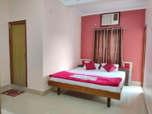 een slaapkamer met een groot bed met roze muren bij Hotel Vaishnavi near Baba Dham Temple in Deoghar