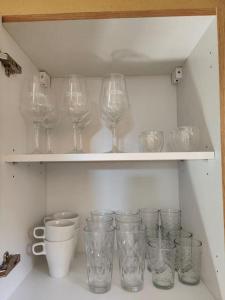une étagère avec des verres à vin et des tasses dans l'établissement Nuit étoilée, à Riddes