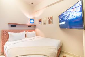 JEMAA EL FNA Suites & Spa في مراكش: غرفة نوم بسرير وتلفزيون بشاشة مسطحة