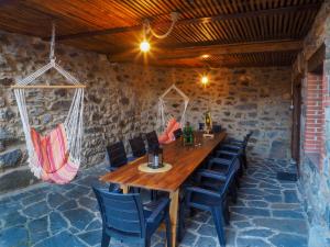 a wooden table and chairs in a room with a stone wall at Posada Real Pajares in Pajares
