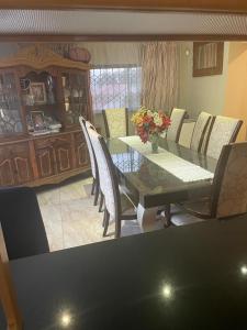 een eetkamer met een tafel en stoelen bij Manors' Holiday Home in Durban
