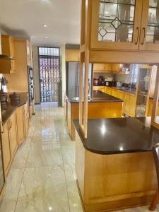een grote keuken met houten kasten en een aanrecht bij Manors' Holiday Home in Durban