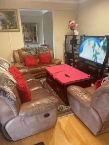 een woonkamer met banken en een flatscreen-tv bij Manors' Holiday Home in Durban