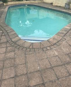 een zwembad met een tegelvloer eromheen bij Manors' Holiday Home in Durban