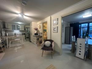 a living room with a chair and a kitchen at Boutique Granny Flat in Paraparap