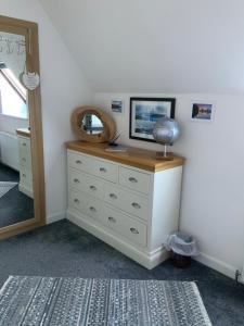 a dresser with a mirror on top of it at Babas rooms in Dunvegan