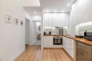 a kitchen with white cabinets and wooden counter tops at Trendy Living in Koukaki! "Hotspot!" Nighttime noise possible in Athens