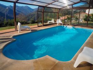 a pool with chairs and a view of the mountains at Posada Real Pajares in Pajares