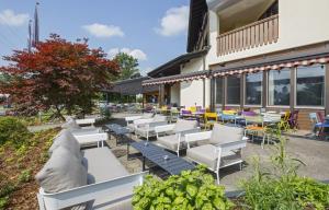 een groep stoelen en tafels buiten een gebouw bij Hotel & Restaurant Chärnsmatt in Rothenburg