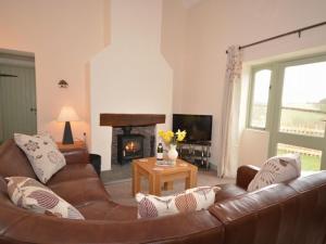 a living room with a leather couch and a fireplace at 2 bed in Watchet OLDSO in Wiveliscombe