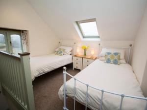 two twin beds in a small room with a window at 2 bed in Watchet OLDSO in Wiveliscombe