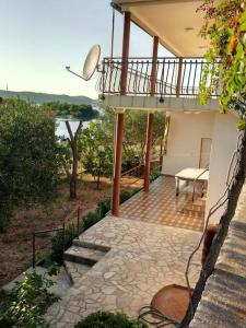 un balcone di una casa con scale e tavolo di Ferienhaus am Wasser - Kuća RiO - iberische Finca in Dalmatien a Bilice (Bilizze)