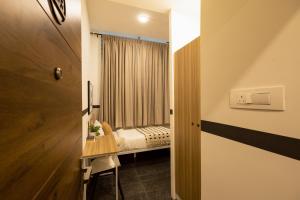 a room with a bed and a table and a room with a window at Olive Domlur - by Embassy Group in Bangalore