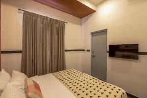 a bedroom with a bed and a flat screen tv at Olive Domlur - by Embassy Group in Bangalore