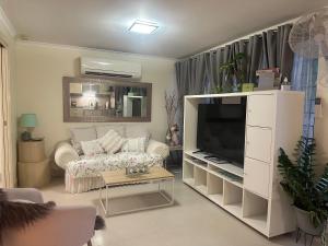 a living room with a couch and a television at Boutique Granny Flat in Paraparap