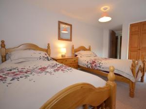 3 Bed in Lyme Regis BARRA في Winsham: سريرين توأم في غرفة نوم بها مصباحين
