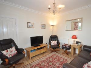 a living room with a tv and two chairs at 2 bed in Huntly AB171 in Huntly