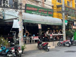 a group of motorcycles parked outside of a restaurant at Happy Apple Guesthouse in Pattaya Central