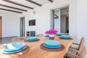 una sala da pranzo con tavolo in legno e piatti blu di Attico Dune Porto Cesareo a Porto Cesareo