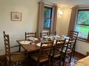 a dining room with a wooden table and chairs at 5 Bed in Castle Douglas KK169 in Castle Douglas
