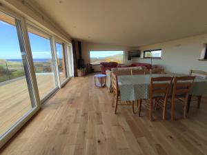 a living room with a table and chairs and a couch at 3 bed in Scourie SU164 in Rhiconich