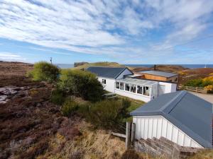 an aerial view of a white house on a hill at 3 bed in Scourie SU164 in Rhiconich