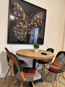 a table and chairs with a heart painting on the wall at Cozy Apartment at Gazi Square in Athens
