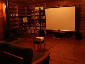 ein Zimmer mit einem großen Bildschirm in einer Bibliothek in der Unterkunft 帳 -TOBARI- in Dazaifu