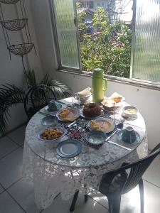 una mesa con platos de comida. en Lua de Aquarius Boutique Hostel, en Tamoios