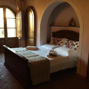 a bedroom with a large bed in a room with two windows at Podere San'tAntonio in Riparbella