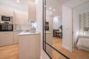 een keuken en een woonkamer met witte kasten bij XPCE Cathedral - Luxury Flat in Málaga