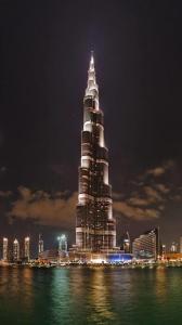 un edificio alto se ilumina por la noche en Dubai Mall Highest Floor With Burj Khalifa View Residence - Formerly Address Dubai Mall, en Dubái