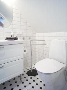 Baño blanco con aseo y lavamanos en Eklinds Rum och Trädgård en Gotemburgo