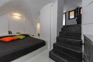 a bedroom with a bed and a staircase at The Luna Suite with jacuzzi in Emporio Santorini