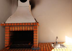 cocina con chimenea de ladrillo y fregadero en MyStay - Casa dos Parentes en Igrejinha