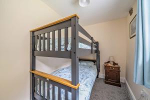 a bunk bed in a room with a bed at Ivy Cottage in Buckland in the Moor